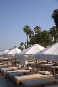 a row of tables with umbrellas on a beach at Kalia Beach Hotel Side in Side