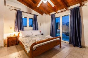 une chambre avec un lit et une grande fenêtre dans l'établissement Ariadne's Retreat, à Oikhalía