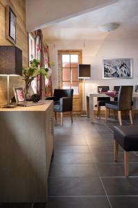 a living room with chairs and a table and a kitchen at CGH Résidence Boutique La Grange aux Fées in Valmorel +27 photos