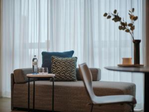 a living room with a couch and a table with a bottle on it at Adina Apartment Hotel Vienna Belvedere in Vienna