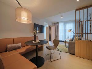 een woonkamer met een bank en een tafel bij Adina Apartment Hotel Vienna Belvedere in Wenen