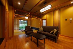 un soggiorno con divano, sedie e tavolo di Yado Shiontei a Yonago