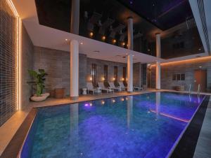 une piscine dans un hôtel avec des chaises autour dans l'établissement Adina Apartment Hotel Vienna Belvedere, à Vienne