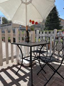 - une table avec un parasol et une chaise fleurie dans l'établissement Cà del Fili, à Lenno