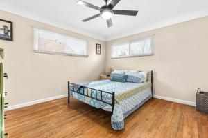 a bedroom with a bed and a ceiling fan at Cozy Ranch Home a Walk from St John's Hospital! in Detroit