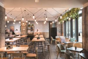 um restaurante com mesas, cadeiras e janelas em Adina Apartment Hotel Copenhagen em Copenhague