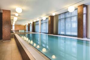 a large swimming pool in a building with windows at Adina Apartment Hotel Copenhagen in Copenhagen