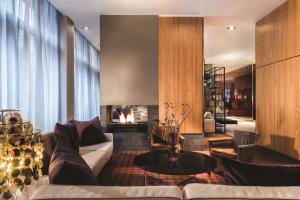 a living room with a couch and a fireplace at Adina Apartment Hotel Copenhagen in Copenhagen