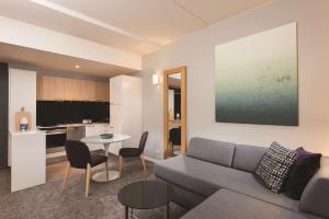 - un salon avec un canapé et une table dans l'établissement Adina Apartment Hotel Copenhagen, à Copenhague