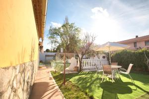 a backyard with a table and an umbrella at Cuencaloft Casa Rural Cañada Molina in Arcas