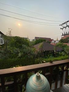 a vase sitting on top of a wooden bench at Living Sage Chiang Mai - Boutique Art House in Chiang Mai