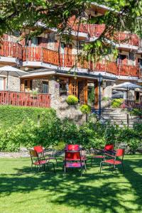 een groep stoelen in het gras voor een gebouw bij Hotel Coma in Ordino