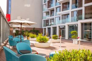 a patio with blue chairs and an umbrella at Barceló Anfa Casablanca in Casablanca