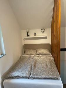 - une chambre avec un lit et une tête de lit en bois dans l'établissement Kuća za odmor u prirodi NINA Jezero Orahovica, à Duzluk