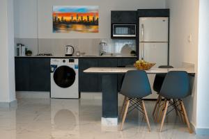 een keuken met een koelkast en een wasmachine bij Al Kawther Hotel Apartments in Amman