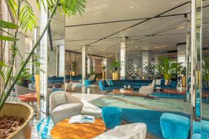 a hotel lobby with blue furniture and plants at Barceló Anfa Casablanca in Casablanca