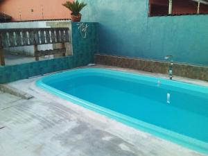 une grande piscine bleue dans un immeuble dans l'établissement Casa familiar quarto, cozinha, banheiro e piscina a praia está a 700 metros, à Peruíbe