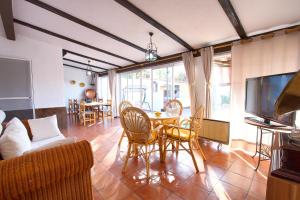 a living room with a table and chairs and a tv at Cuencaloft Casa Rural Cañada Molina in Arcas