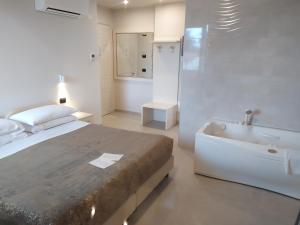 a white bedroom with a bed and a bath tub at Garda Diamant in Desenzano del Garda