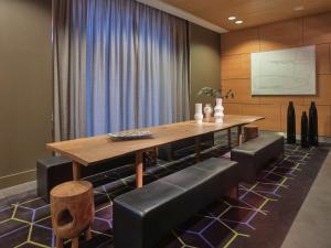 une salle à manger avec une table en bois et des fauteuils en cuir dans l'établissement Adina Apartment Hotel Berlin Hackescher Markt, à Berlin