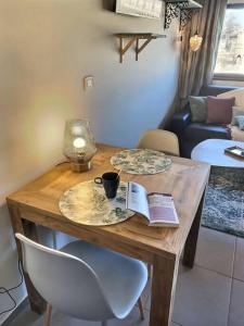a wooden table with a cup and a book on it at Le Saint Roch 2 - AC CLIM - WIFI - 50m Centre ville in Avignon