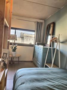 Schlafzimmer mit einem Bett, einer Leiter und einem Spiegel in der Unterkunft Le Saint Roch 2 - AC CLIM - WIFI - 50m Centre ville in Avignon