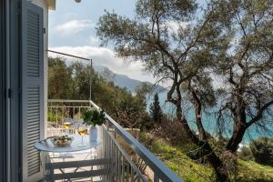 a table on a balcony with a view of the water at Villa Rustica in Agios Gordios