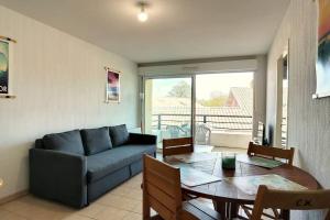 ein Wohnzimmer mit Sofa und Tisch in der Unterkunft V-Mimosas 01-Vieux Boucau Appartement 6 personnes calme au cœur de Vieux Boucau proche skatepark in Vieux-Boucau-les-Bains
