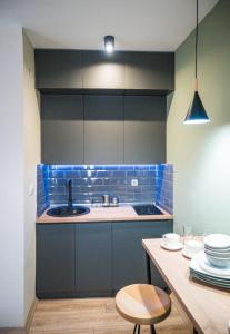 a kitchen with blue tiles and a sink and a table at BEST APARTMENTS in Bitola
