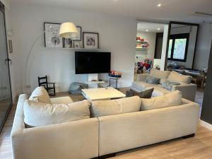 ein Wohnzimmer mit einem weißen Sofa und einem TV in der Unterkunft Casa en Sant Cugat in Sant Cugat del Vallès