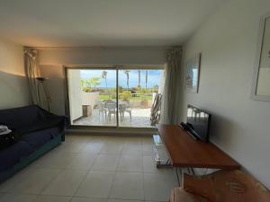 salon z kanapą i stołem w obiekcie PAN0 - Studio avec belle et grande terrasse vue mer w Cannes