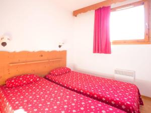 ein Schlafzimmer mit einer roten Tagesdecke mit weißen Polka-Punkten in der Unterkunft Location 3 Pièces 6 Pers avec Balcon à Puy-Saint-Vincent - FR-1-504-81 in Puy-Saint-Vincent + 6 Fotos