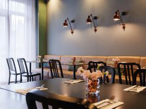 une salle à manger avec des tables, des chaises et des lumières dans l'établissement Adina Apartment Hotel Berlin Mitte, à Berlin