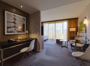 a living room with a dining area and a living room with at Adina Apartment Hotel Berlin Mitte in Berlin