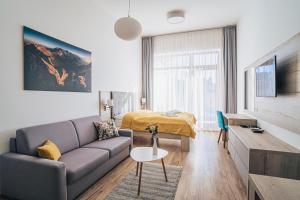 a living room with a couch and a bed at Apartmány Tatry in Vysoke Tatry - Stary Smokovec