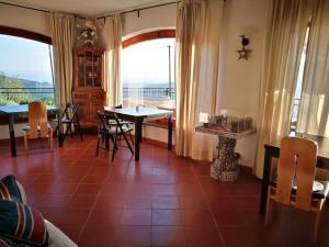 ein Wohnzimmer mit einem Tisch, Stühlen und einem Fenster in der Unterkunft BeB La Terrazza Sui Fieschi in Cogorno