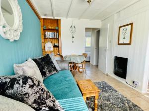 a living room with a couch and a table at Lucy Lou, charming holiday bungalow in Devon in Galmpton-on-the-Dart