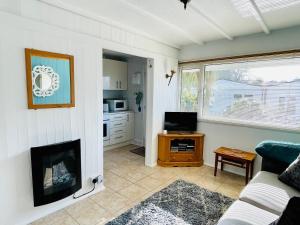 a living room with a couch and a fireplace at Lucy Lou, charming holiday bungalow in Devon in Galmpton-on-the-Dart