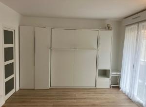 ein großer weißer Schrank in einem Zimmer mit Holzböden in der Unterkunft Paris 42m Studio plus terrace in Paris