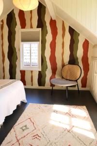 een slaapkamer met een bed, een raam en een stoel bij Slapen bie Wisse in Kamperland
