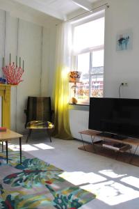 een woonkamer met een flatscreen-tv en een stoel bij Slapen bie Wisse in Kamperland