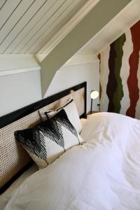 een bed met zwart-witte kussens in een kamer bij Slapen bie Wisse in Kamperland