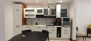 a kitchen with white cabinets and a black table at Putignani Exclusive Suite in Bari