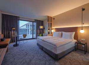 a hotel room with a large bed and a large window at Adina Apartment Hotel Cologne in Cologne