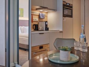 a small room with a table and a bed at Adina Apartment Hotel Cologne in Cologne