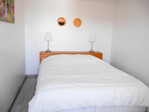 uma cama branca num quarto com duas lâmpadas em Appartement Le Palais, 2 pièces, 6 personnes - FR-1-418-177 em Le Palais