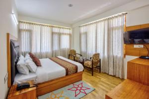 - une chambre avec un lit, une télévision et un bureau dans l'établissement Thrill Nature Cottage, à Manali