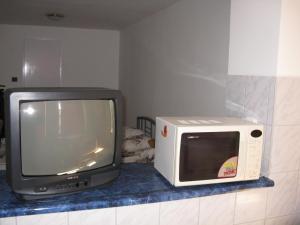 a microwave and a television sitting on a counter at Kárpáti Motel in Budapest