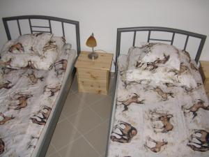 2 camas individuales en un dormitorio con mesita de noche en Kárpáti Motel, en Budapest