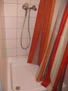 W łazience znajduje się prysznic i wanna. w obiekcie Kárpáti Motel w Budapeszcie